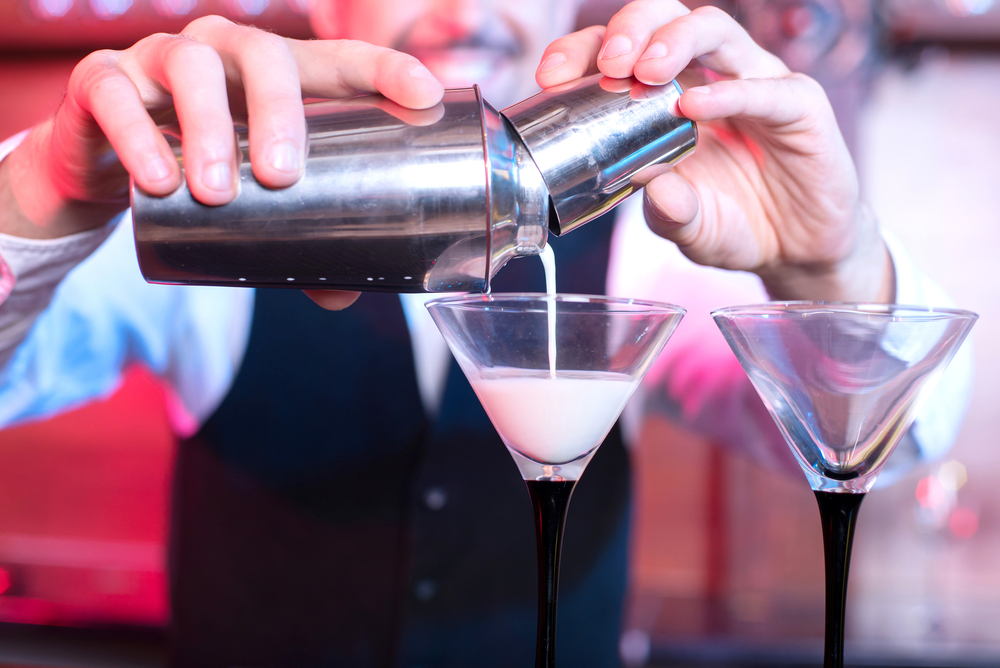 A bartender making drinks; the best way to avoid date rape and roofies is to keep an eye on your drink at all times.