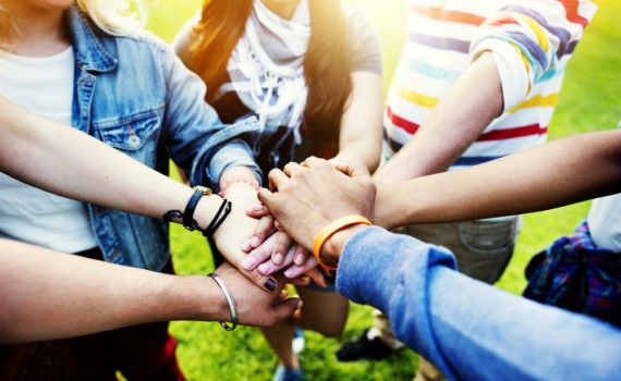Students who received scholarships for American Indians hold hands.