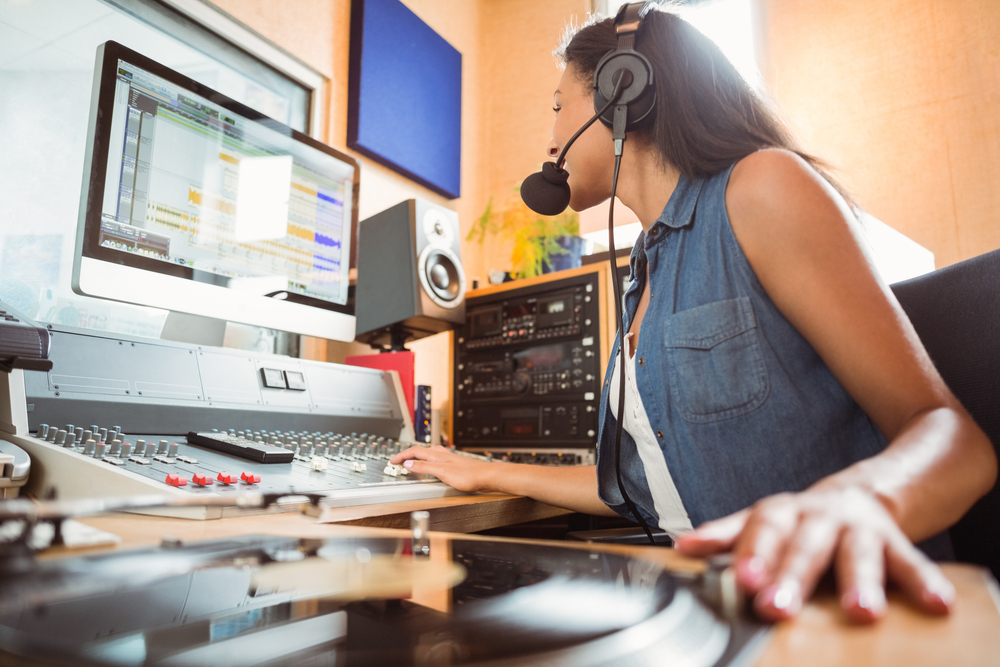A girl uses controls to broadcast a radio show; there are unique scholarships for students who have an amateur radio license.
