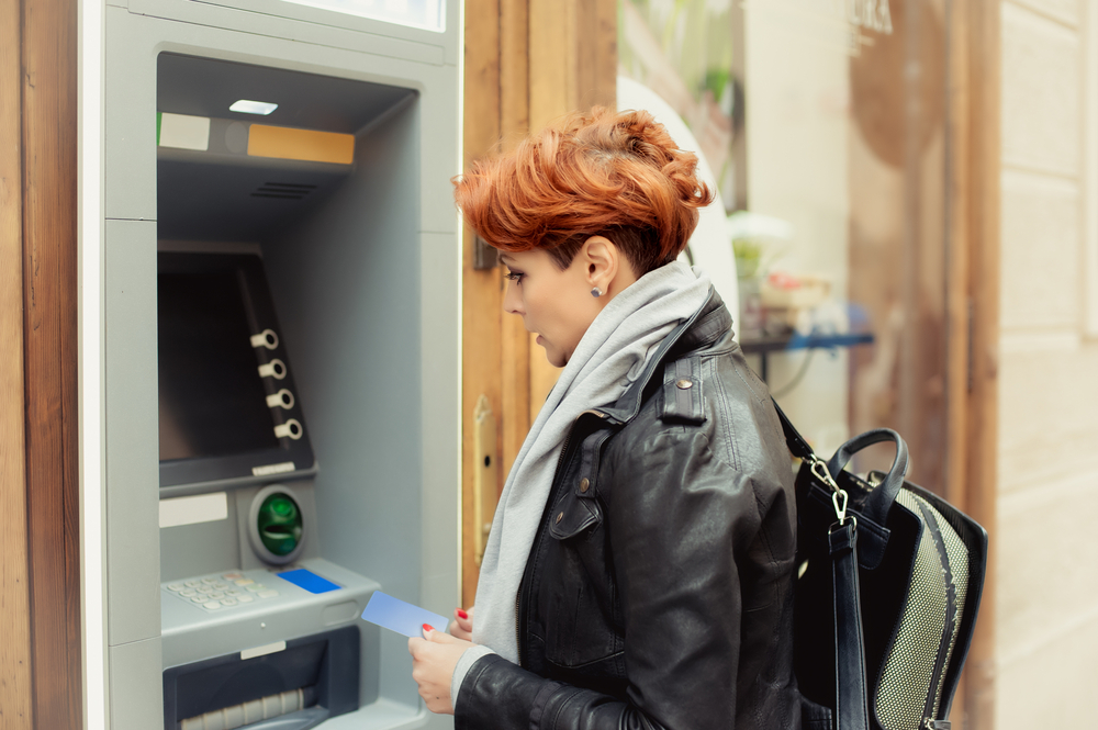 A woman uses her debit card to access one of her no-fee student checking accounts